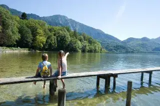 20210416_Kochelsee_Tölzer_Land_Tourismus Zwei Kinder sitzen auf einem Steg am Kochelsee