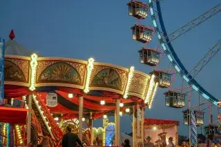 Das tradtionelle Fahrgeschäft Krinoline auf dem Oktoberfest mit Riesenrad im Hintergrund.