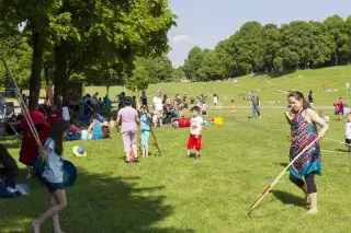210228_spielaktionen-sommer-westpark_Mde-KatySpichal Kinder und Eltern spielen auf einer großen Wiese bei der Spielaktion im Sommer im Westpark