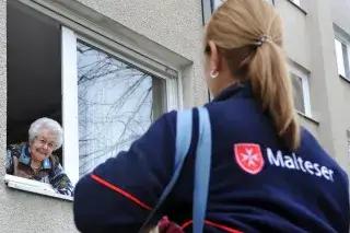 20210818_Katholische_Kirche Einer Mitarbeiteren der Malteser unterhält sich mit einer Rentnerin