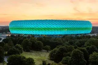 Allianz Arena in türkiser Beleuchtung beim Sonnenuntergang Die Münchner Fußball Arena in türkiser Beleuchtung beim Sonnenuntergang im Abendrot