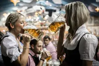 20210812_Wiesn_Infos_Services Besucherinnen im Hacker Festzelt trinken Oktoberfestbier aus Maßkrügen
