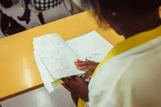 20210811_Realschulabschluss_nachholen Eine Schülerin der Städtischen Franz-Auweck-Abendschule blättert in ihren Unterlagen