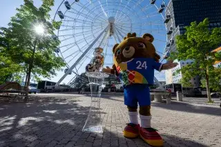 Die EM-Trophäe in München mit Maskottchen Albärt vor dem Umadum-Riesenrad Die EM-Trophäe in München mit Maskottchen Albärt vor dem Umadum-Riesenrad