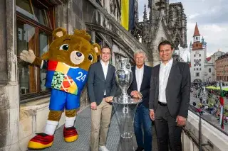 The European Championship trophy on the Munich City Hall balcony with mascot Albärt, Tournament Director Philipp Lahm, Lord Mayor Dieter Reiter and Host City Ambassador Dr. Felix Brych Der EM-Pokal auf dem Münchner Rathausbalkon mit Maskottchen Albärt, Turnierdirektor Philipp Lahm, Oberbürgermeister Dieter Reiter und Host City Botschafter Dr. Felix Brych